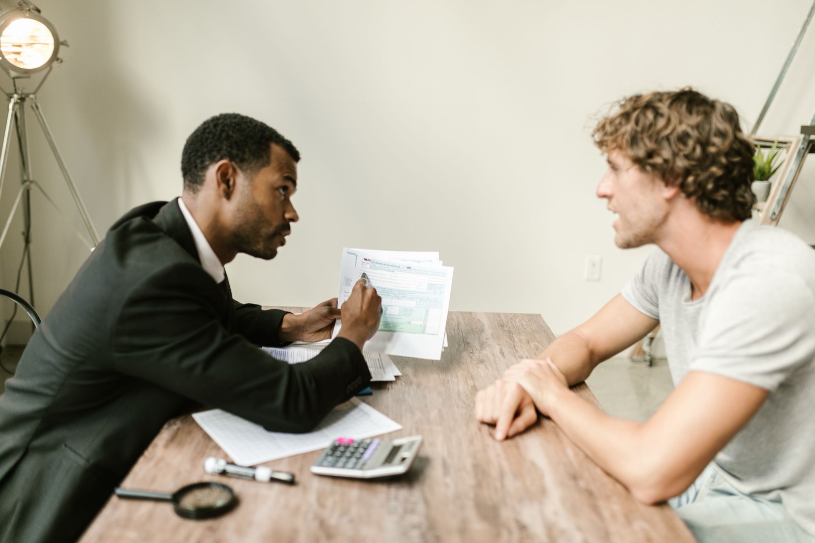 An accountant going over tax forms with a client at a desk