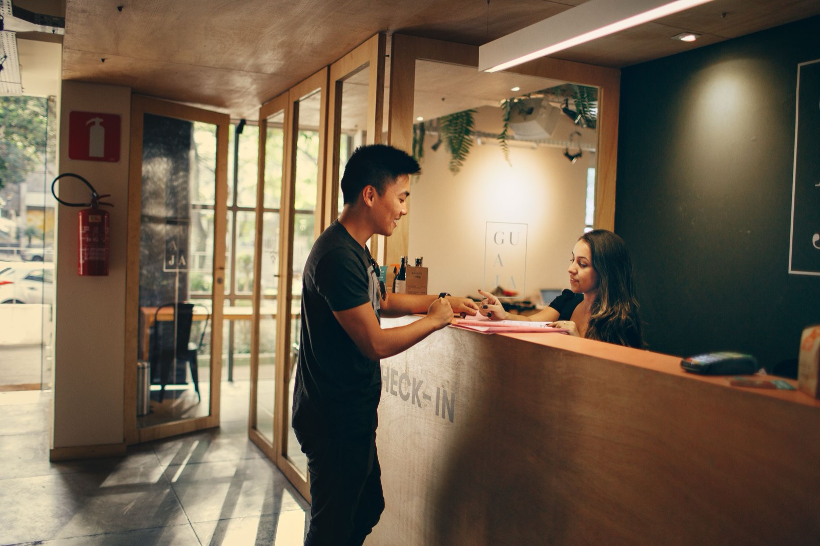 A front desk clerk checking in a guest at a hotel reception