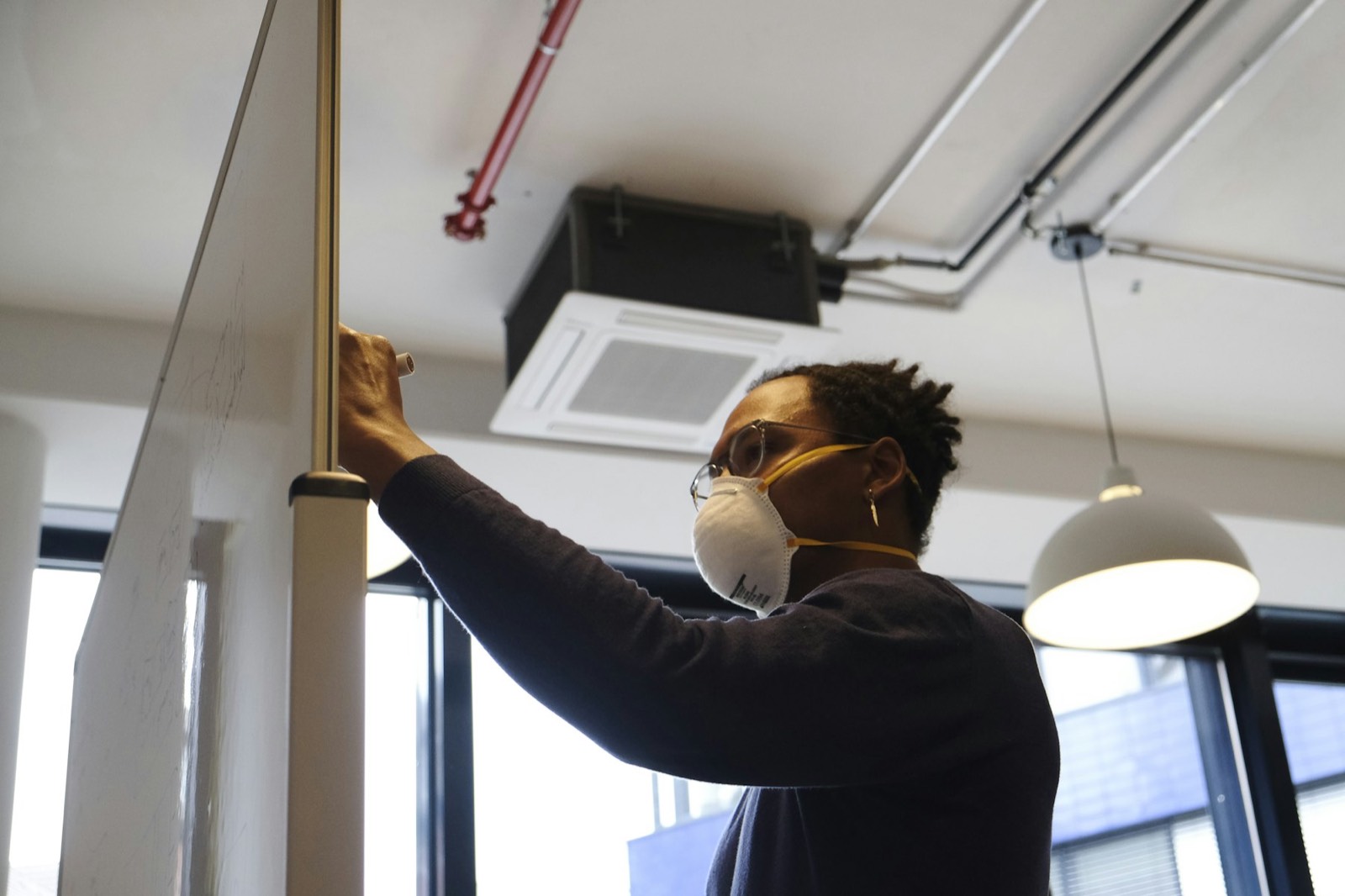 An HVAC technician installing a ceiling air conditioner