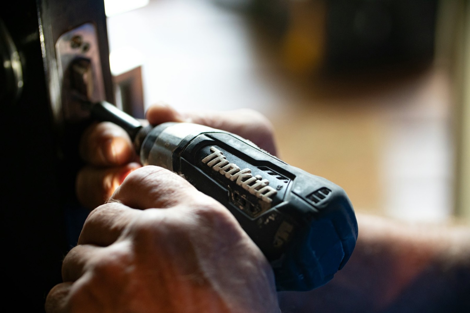 A locksmith drilling out a door lock